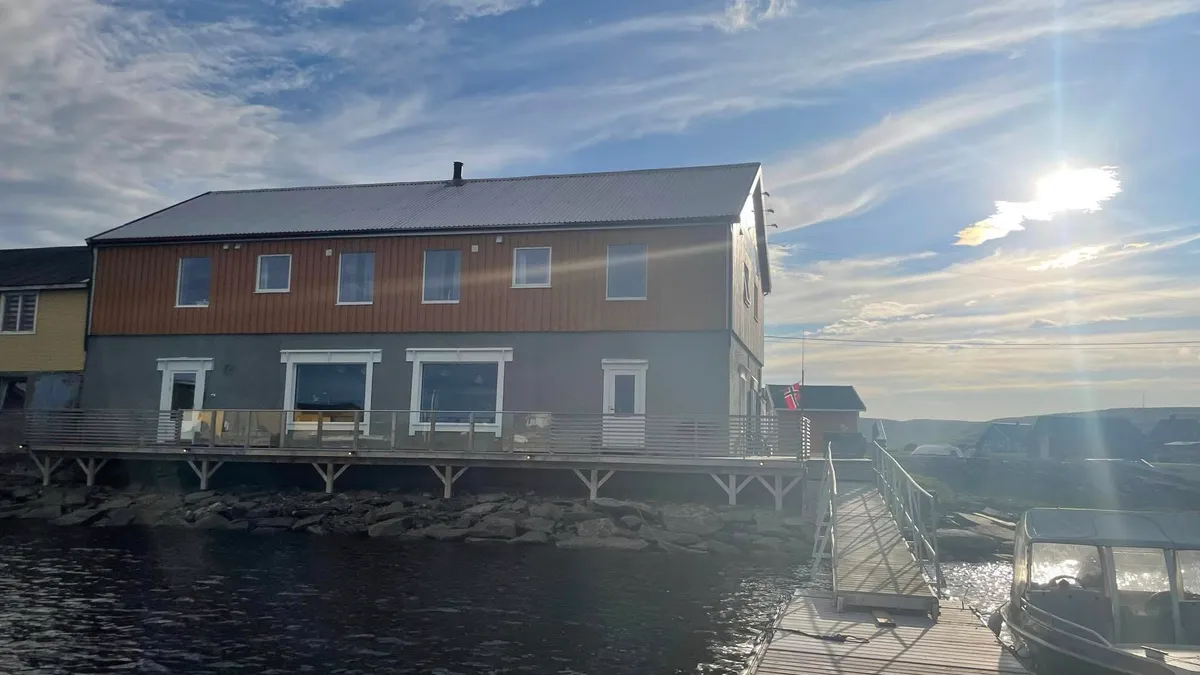 Jakobselvkaia gjestehus sett fra sjøsiden en solfylt dag