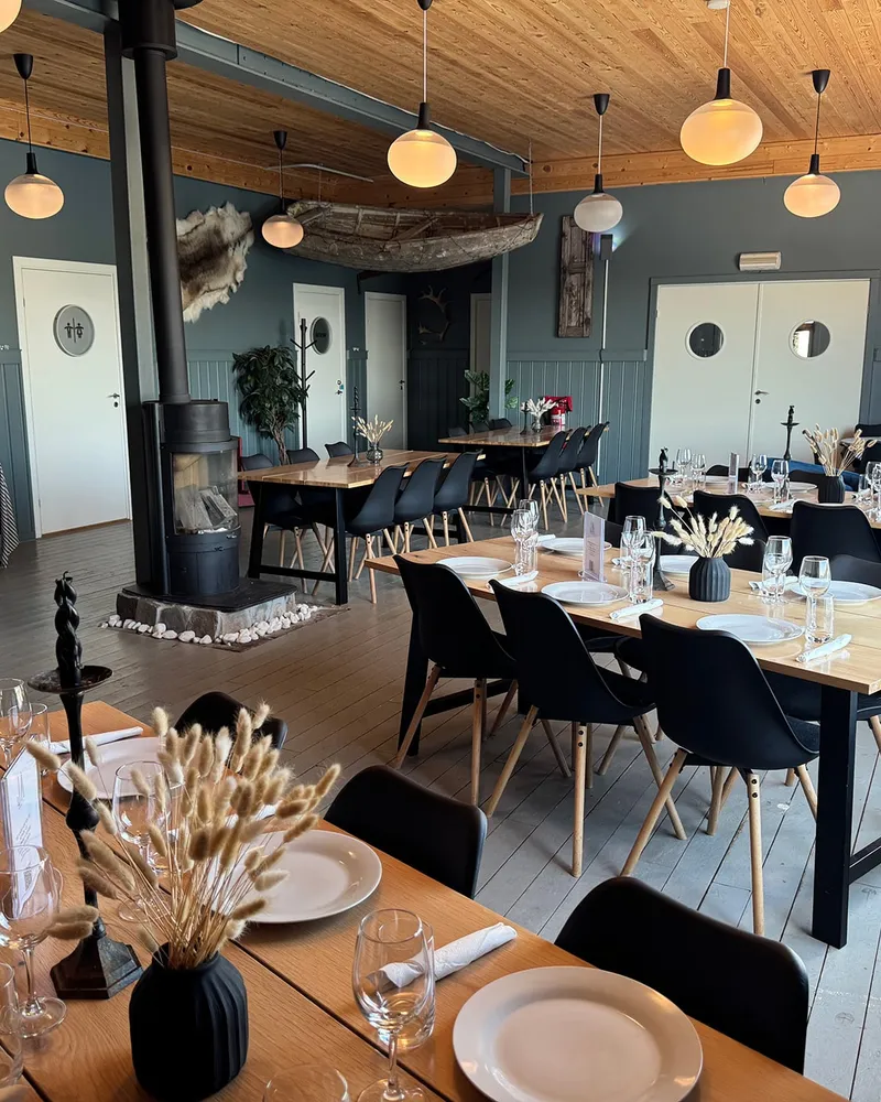Dekkede bord i restauranten på Jakobselvkaia, med reinskinn og vedovn