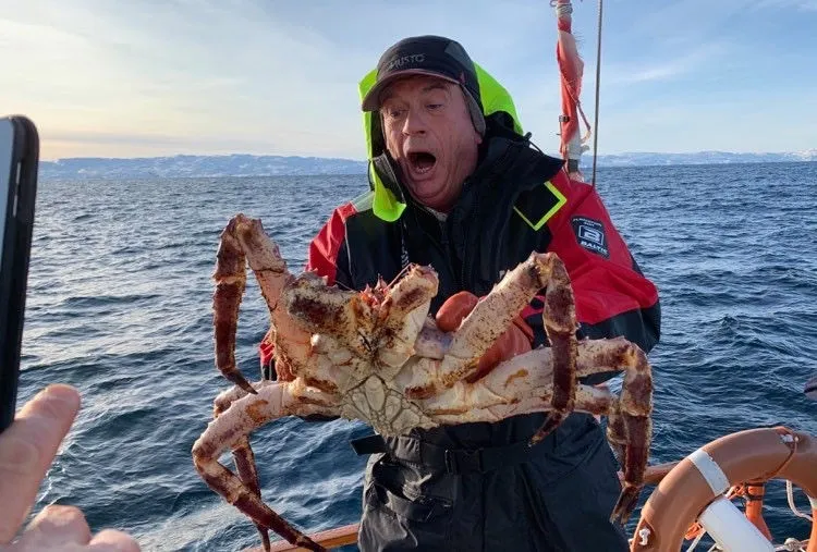 Gjest med nyfanget kongekrabbe om bord hos Sailing The Good Life
