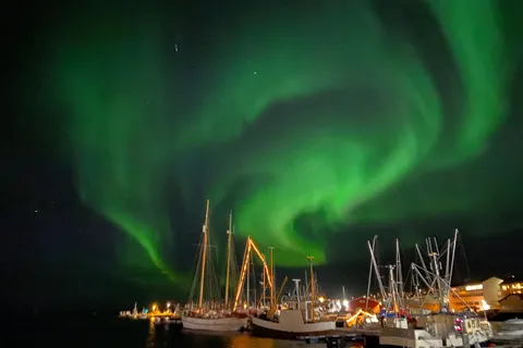 Northern lights over the fishing boats in Vadsø harbour