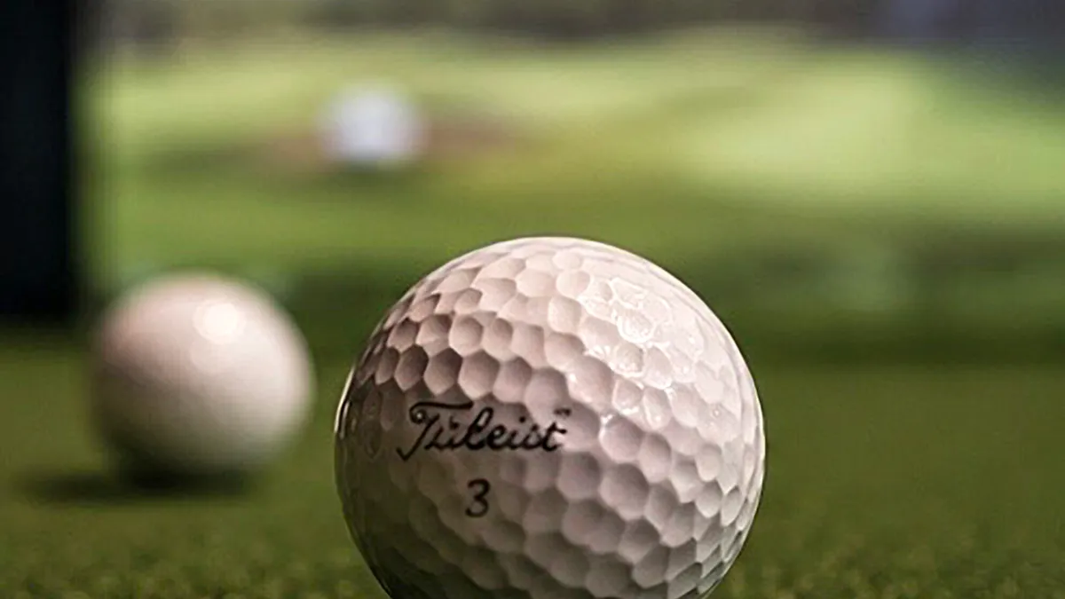 Golf ball on artificial turf in front of the simulator screen at Vadsø Golf Lounge