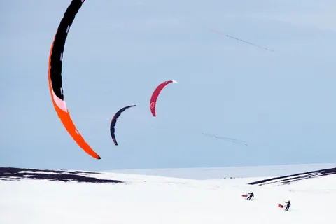 Snowkiters with colourful kites over the snow-covered plateau on the Varanger Peninsula