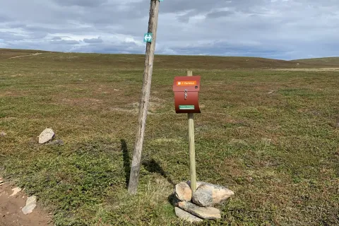 Perletur sign and postbox on open tundra by Vasavannet